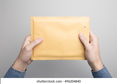 Hand Holding Blank Padded Envelope Mock-up, Ready To Replace Your Design.