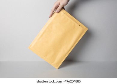 Hand Holding Blank Padded Envelope Mock-up, Ready To Replace Your Design.