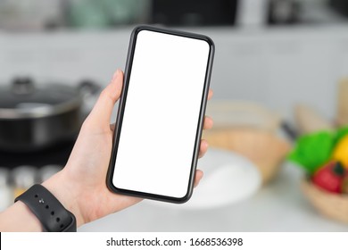 Hand holding blank screen of smartphone at home in kitchen. for graphic display montage. - Powered by Shutterstock