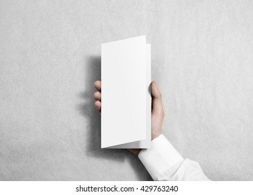 Hand Holding Blank White Flyer Brochure Booklet In The Hand. Leaflet Presentation. Pamphlet Hold Hand. Man Show Fold Offset Paper. Sheet Template. Booklet Design. Display Read First Person