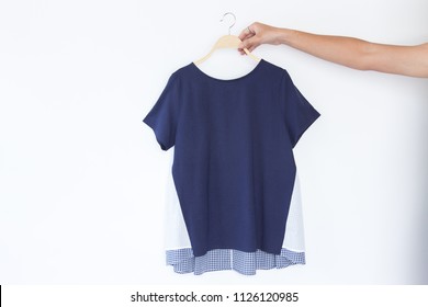 Hand Holding Blue Colour Clothing Is Clothes Hanger On White Background.close Up