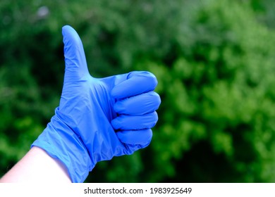 A Hand Holding A Blue Frisbee. High Quality Photo