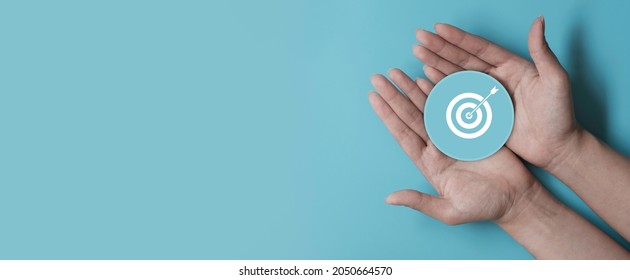 Hand holding blue paper cut with target icon, business strategy, Action plan, Goal and target, business development concept, copy space - Shutterstock ID 2050664570