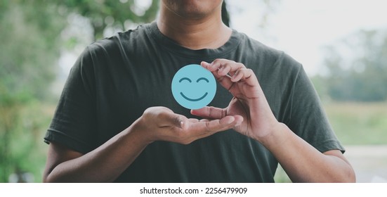 Hand holding blue paper cut happy smile face, positive thinking, mental health assessment , world mental health day concept	 - Shutterstock ID 2256479909