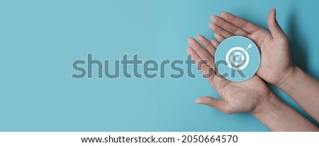 Hand holding blue paper cut with target icon, business strategy, Action plan, Goal and target, business development concept, copy space