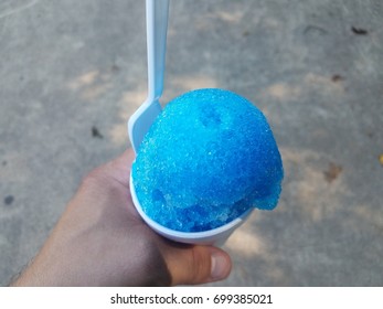 Hand Holding Blue Snow Cone In A Cup