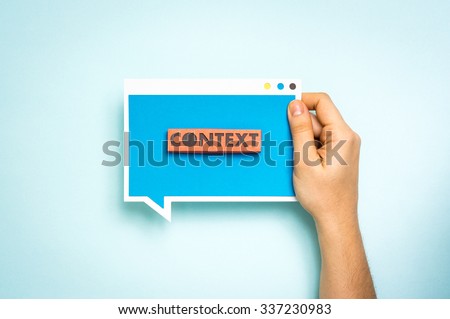 Hand holding blue speech bubble with the text 