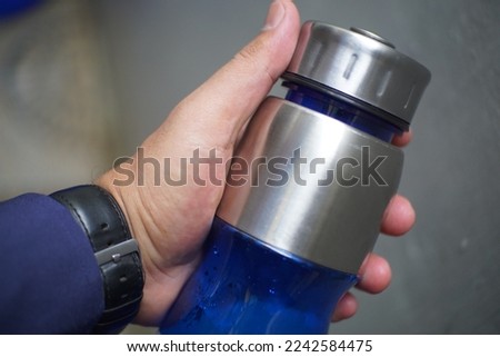 hand holding a blue tumblr bottle