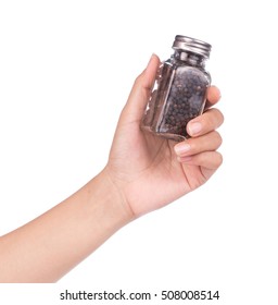 Hand Holding Bottle Of Black Pepper And Coriander Seeds Isolated On White Background