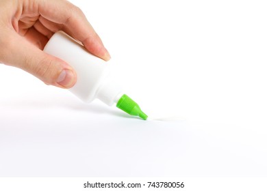 Hand Holding A Bottle Of Glue. Deals PVA Glue On Paper. Isolated On White Background.