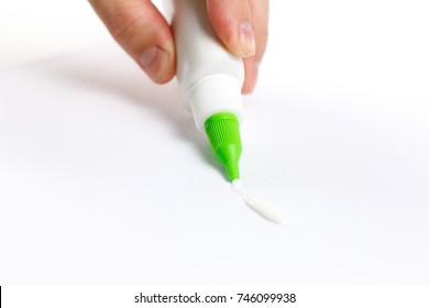 Hand Holding A Bottle Of Glue. Deals PVA Glue On Paper. Isolated On White Background.