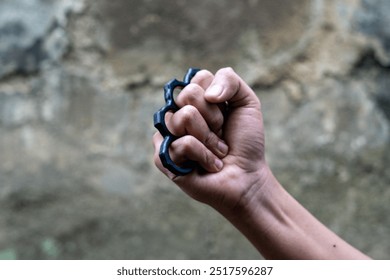 hand holding brass knuckle photo from close in the afternoon