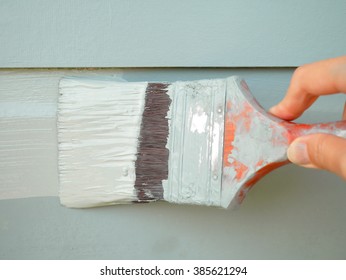 Hand Holding Brush Painting Timber Wall