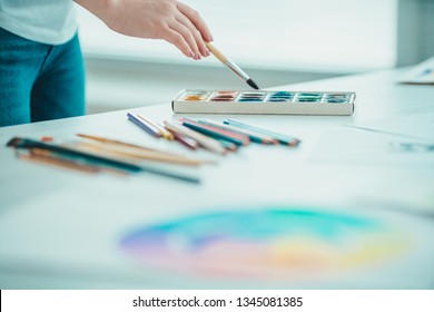 The hand holding a brush at the table - Shutterstock ID 1345081385