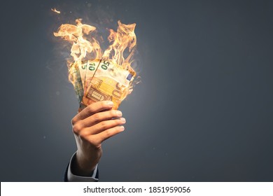 Hand holding burning Euro banknotes