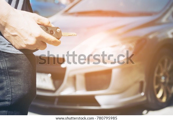 Hand holding
button on the remote car of men hand presses on the remote control
car alarm systems.selective focus
