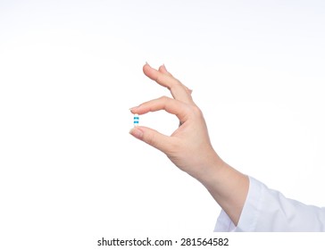 Hand Holding A Capsule Or Pill Isolated On White