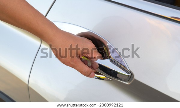 Hand holding car door\
handle
