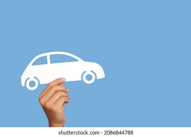 Hand Holding Car Paper Cut Model On Blue  Background. Cost Of Car Concept.Car Insurance.