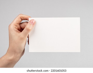 Mofa de la tarjeta de mano sobre fondo gris. Espacio vacío para felicitaciones, invitaciones, notas. Papel en posición horizontal. Foto de alta calidad