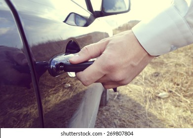 a hand holding a car's remote control pointing to the door.a man opens a machine - Powered by Shutterstock