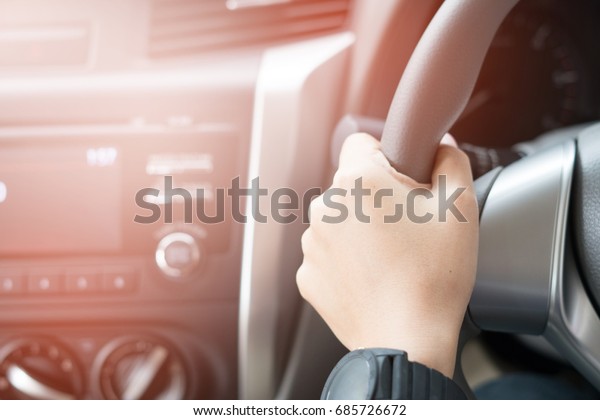 hand holding a car\'s\
steering wheel