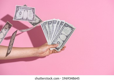 Hand Holding Cash On A Pink Wall Background