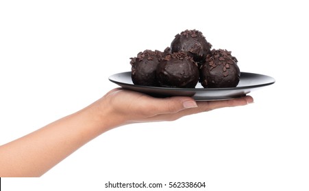 Hand Holding Chocolate Ball On Plate Isolated On A White Background