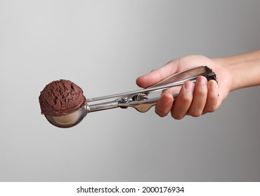 Hand Holding Chocolate Ice Cream In Spoon For Scoop Isolated On Gray Background