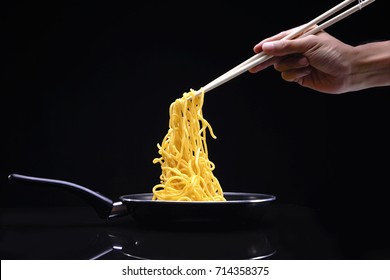 Hand Holding Chopsticks, Eating Noodles Isolated On Black Background