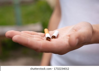 Hand Holding Cigarette Broken In Half Close-up. Health Concept, Stop Smoking, Bad Habit, Harm From Tobacco Use, Addiction, No Smoking.