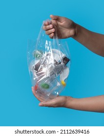 Hand Holding Clear Plastic Bag Of Garbage Isolated On White Background