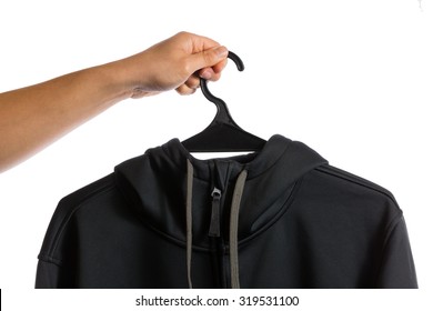 Hand Holding Cloth Hanger With Black Hoody Isolated On White Background