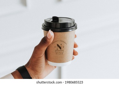 Hand holding a coffee cup mockup