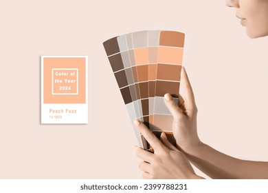 Hand holding Color samples palette design catalog. New trending PANTONE Peach Fuzz colour of 2024 year - Powered by Shutterstock