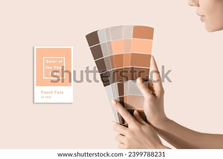 Hand holding Color samples palette design catalog. New trending PANTONE Peach Fuzz colour of 2024 year Stockfoto © 