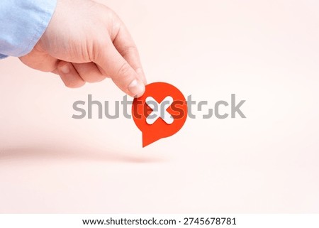 A hand holding a comment cloud with an X signifying rejection. Saying no and refusing to cooperate with denial feedback negative review and online reputation management concept.