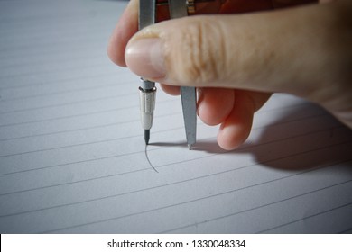 A Hand Holding A Compass For Drawing A Circle On The Notebook Paper, Use Compass For Drawing A Circle