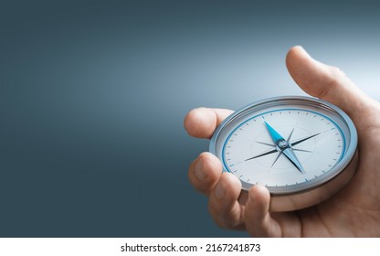 Hand holding a compass over blue background with copy space. Concept of Strategic orientation in business or marketing. Composite image between a 3d illustration and a photography. - Shutterstock ID 2167241873