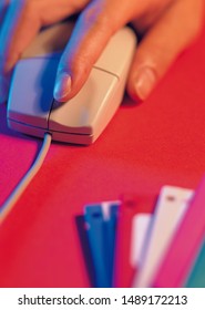 Hand holding computer mouse facing towards camera