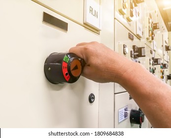 Hand holding the control panel of the industrial plant and pushing or turning the button in electrical selector switch,button switch motor control center cabinet - Shutterstock ID 1809684838