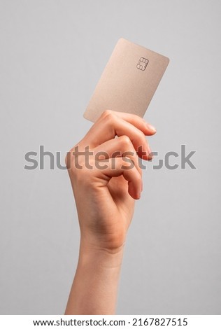 Hand holding credit card mockup with chip. Buying at stores, making transactions at terminals. Secure payments. High quality photo