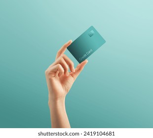 Hand holding credit card on turquoise background.