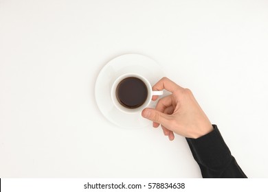 A Hand Holding A Cup Of Coffee On White Background. Top View