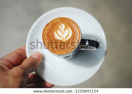 hand holding a cup of espresso machiato