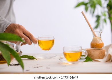 Hand holding a cup of tea.