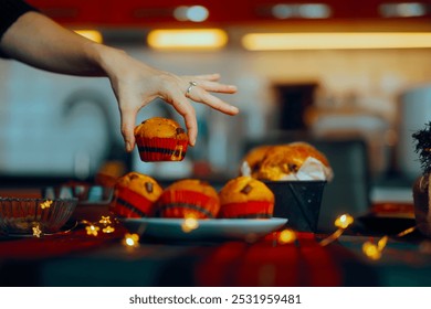 
Hand Holding a Cupcake from the Christmas dinner table. Hungry person stealing dessert for a family gathering meal
 - Powered by Shutterstock