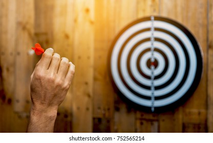 Hand holding a dart getting ready to hitting in the target - Shutterstock ID 752565214