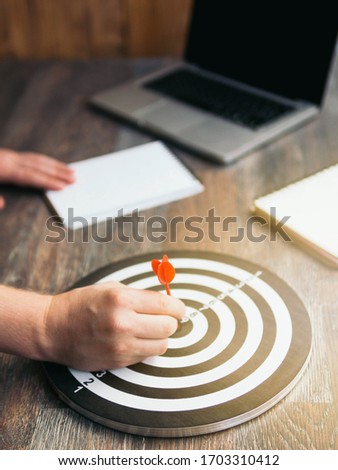 Hand Holding dart throwing to dartboard for final score target business concept