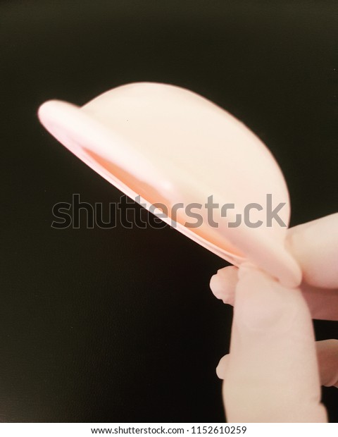Hand holding a\
diaphragm contraceptive method\
